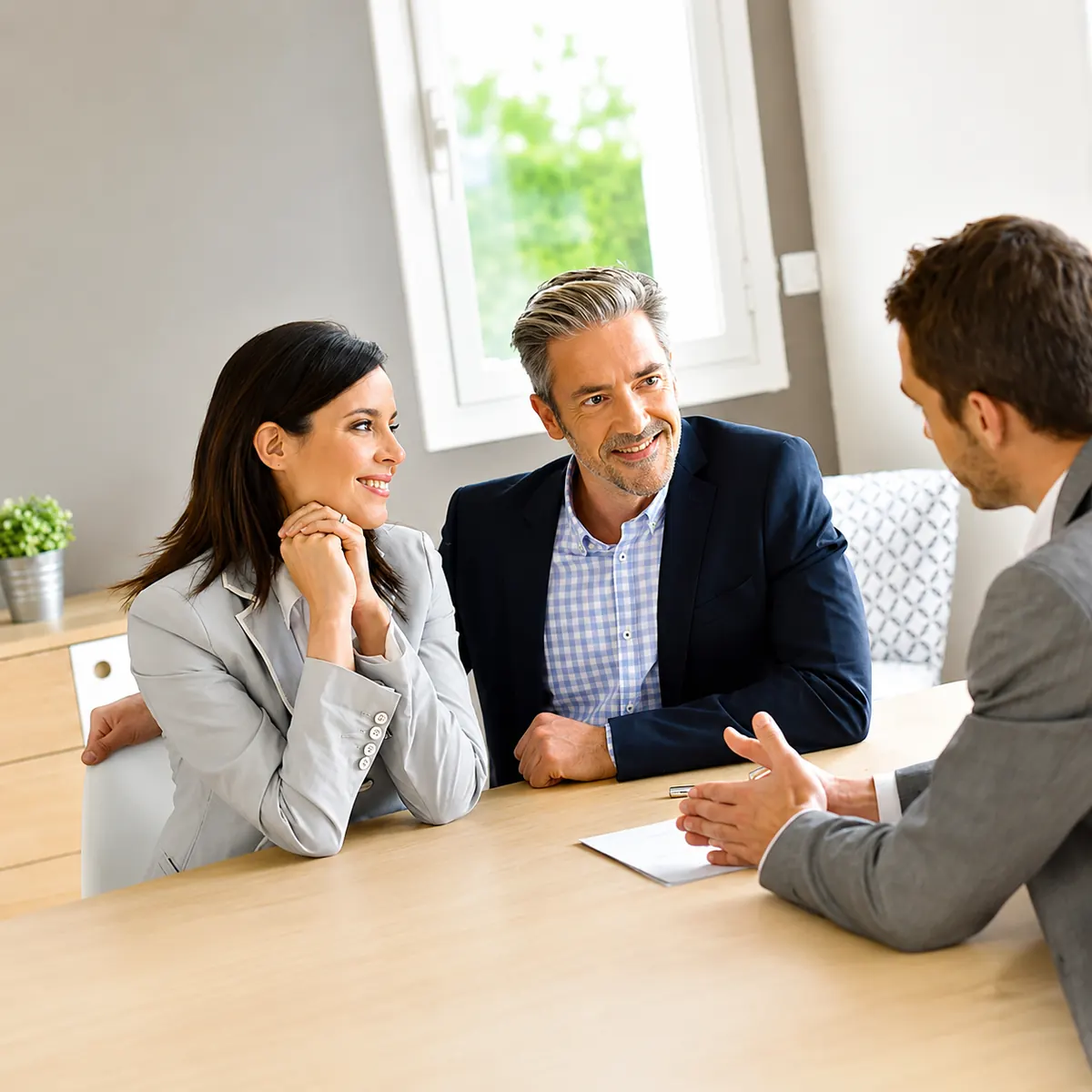 Couple souriant en rendez-vous avec un conseiller NEOXA FINANCE pour une assistance professionnel